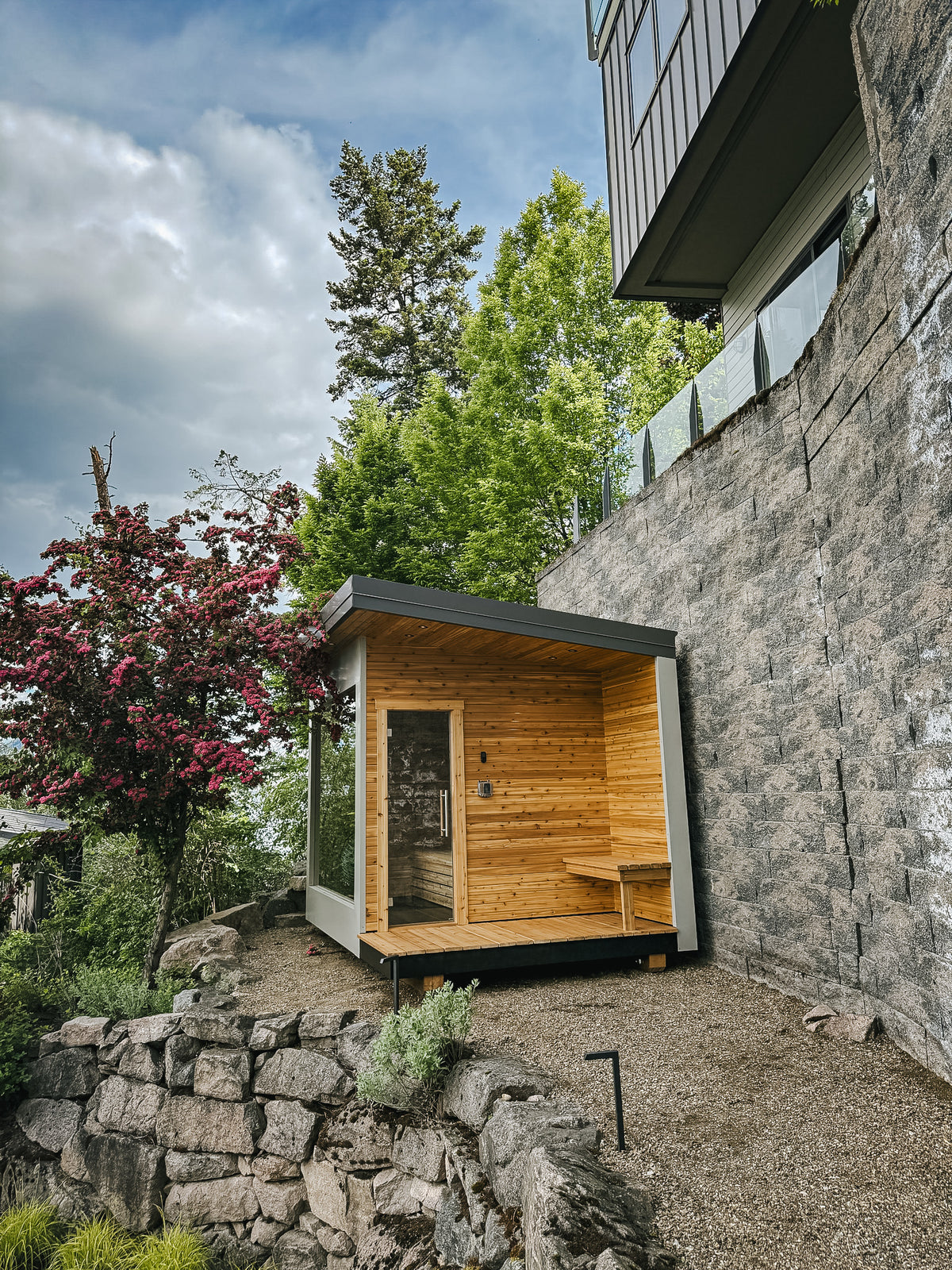 Finished cedar sauna on a lower terrace with the main house above