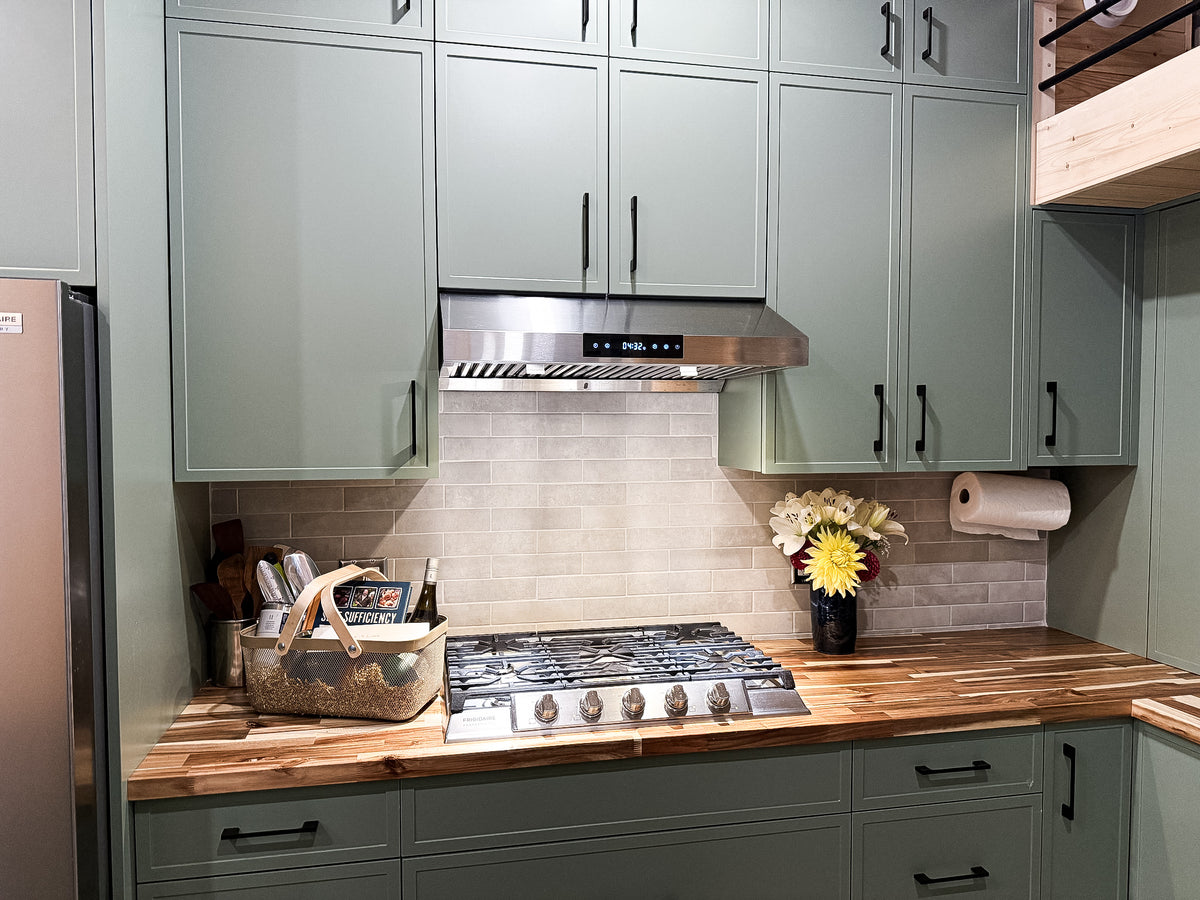 Frigidaire Professional countertop range and hood fan with natural stone tile backsplash and butcher block counters