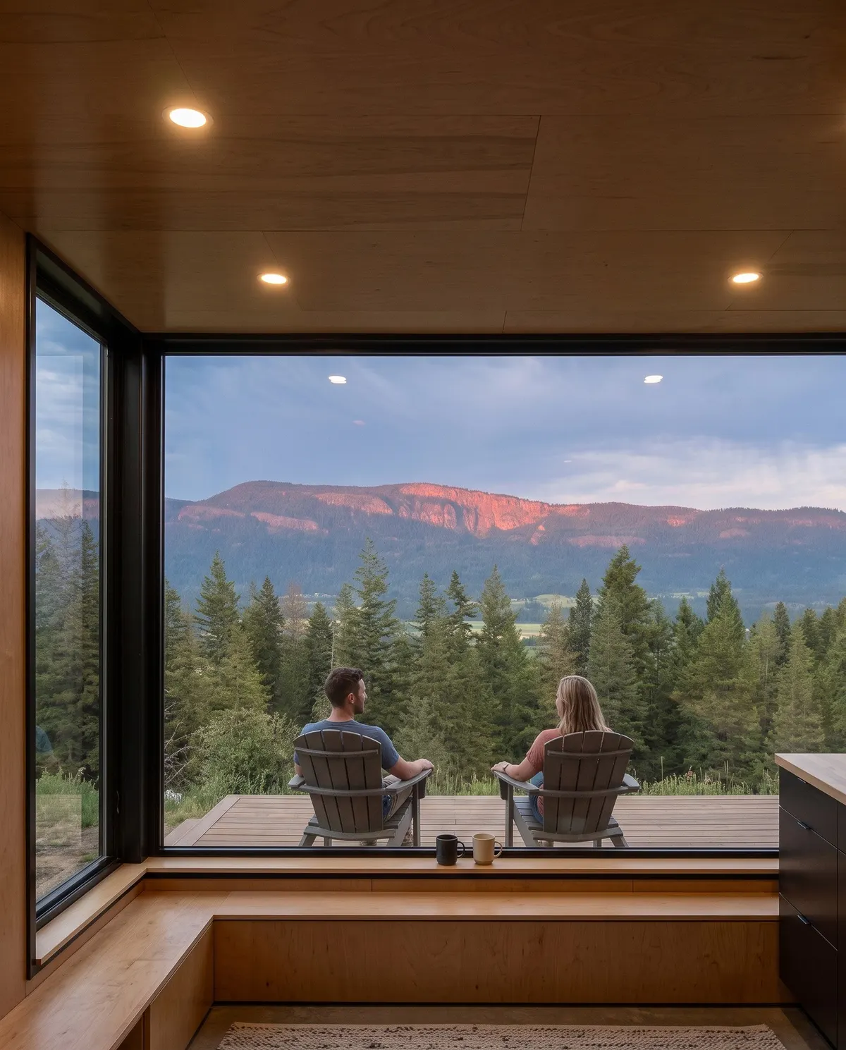 A couple looking out over the valley from a cabin window