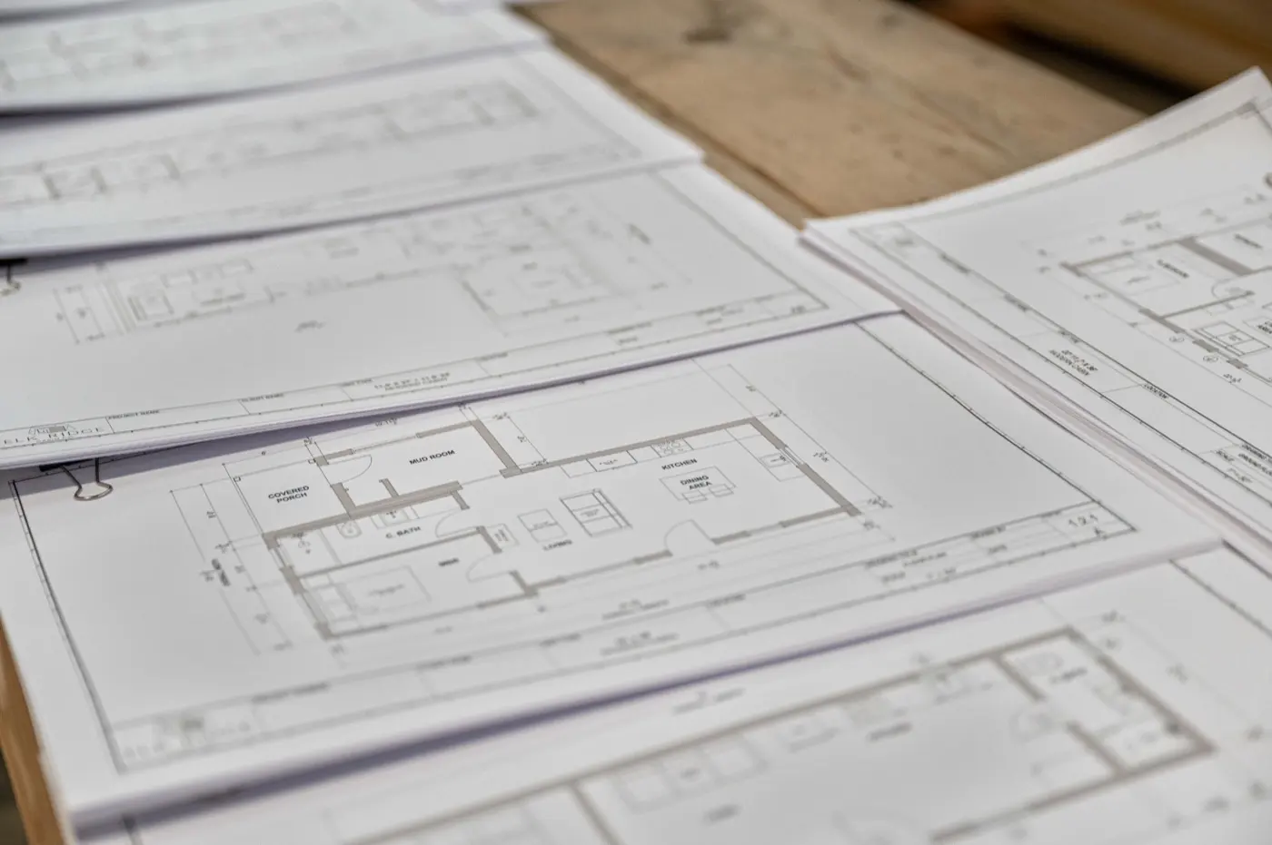 Printed Elk Ridge floor plans and permit drawings spread on a table