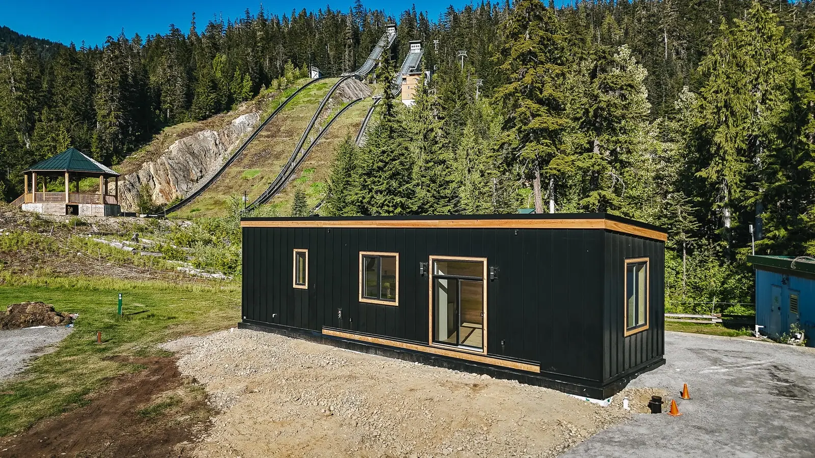 The finished 14' x 48' MODERN 2 Bedroom in black standing seam metal with cedar trim, set at an RV park outside Whistler, BC